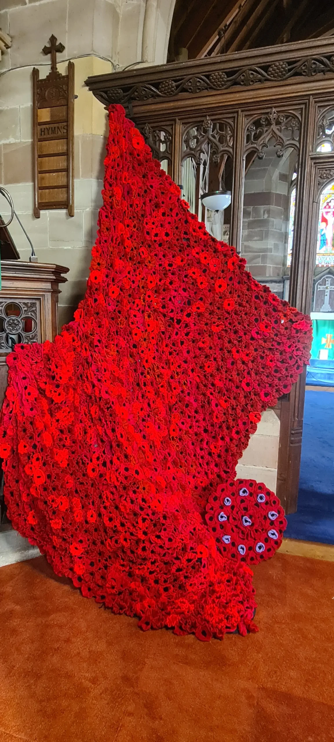 Poppies cascading from the Rood Screen over the pulpit in St Philip's Church