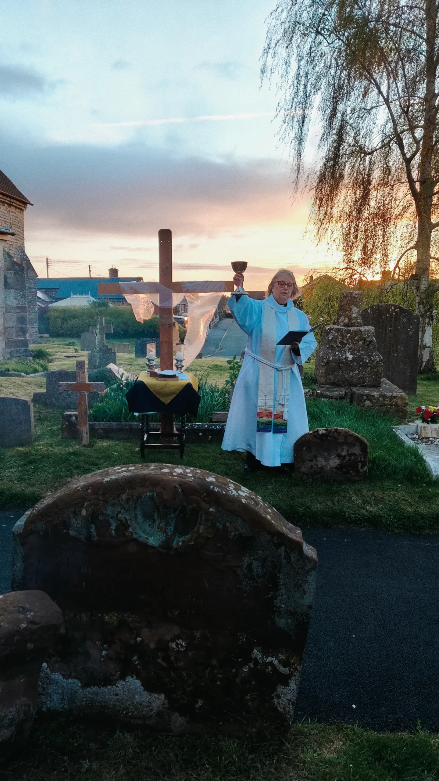 Revd Claire Billington celebrating communion outside Upton Snodsbury church as the sun rises