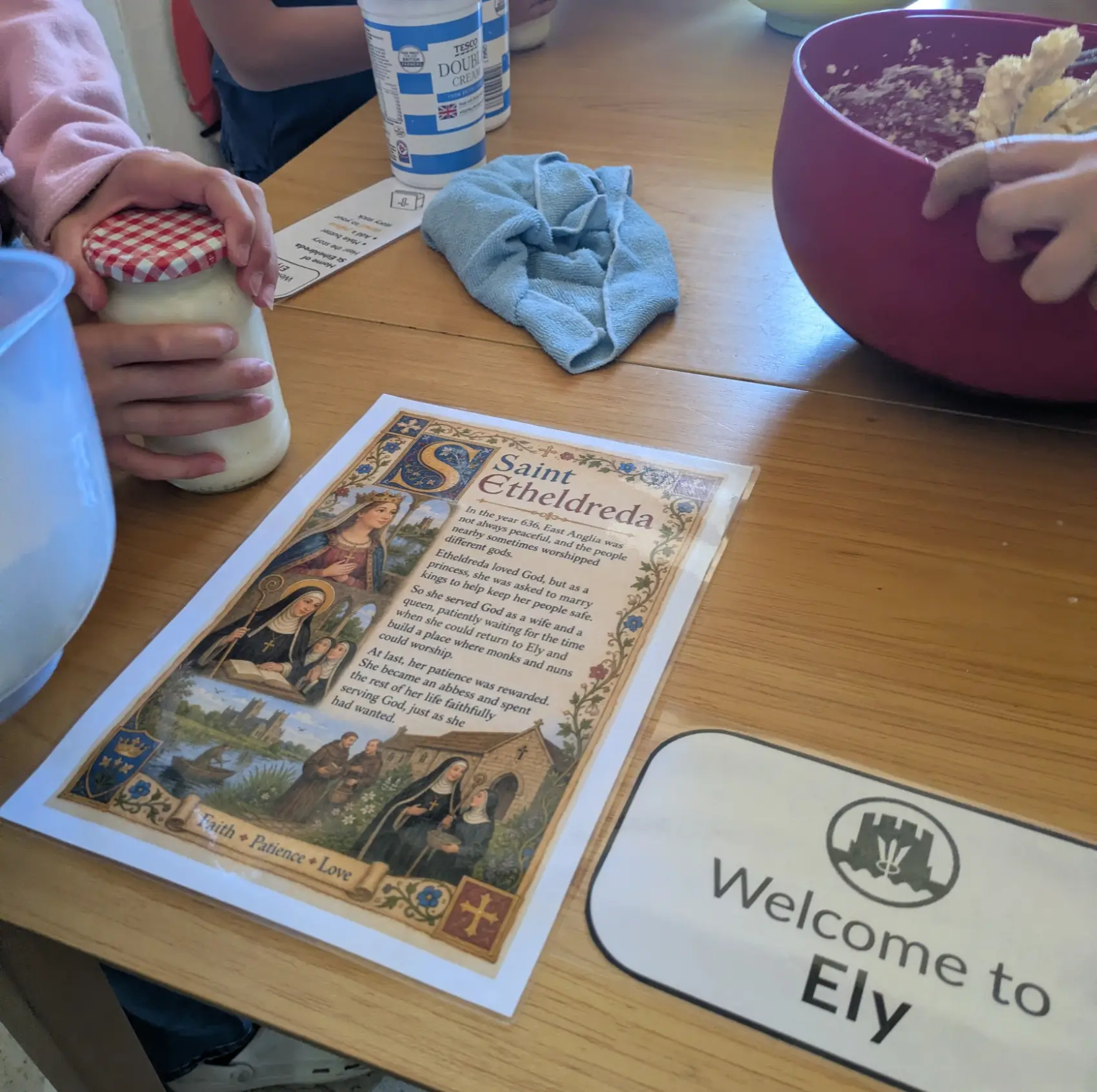 A poster with details of St Etheldreda with two hands with the ingredients to make scones