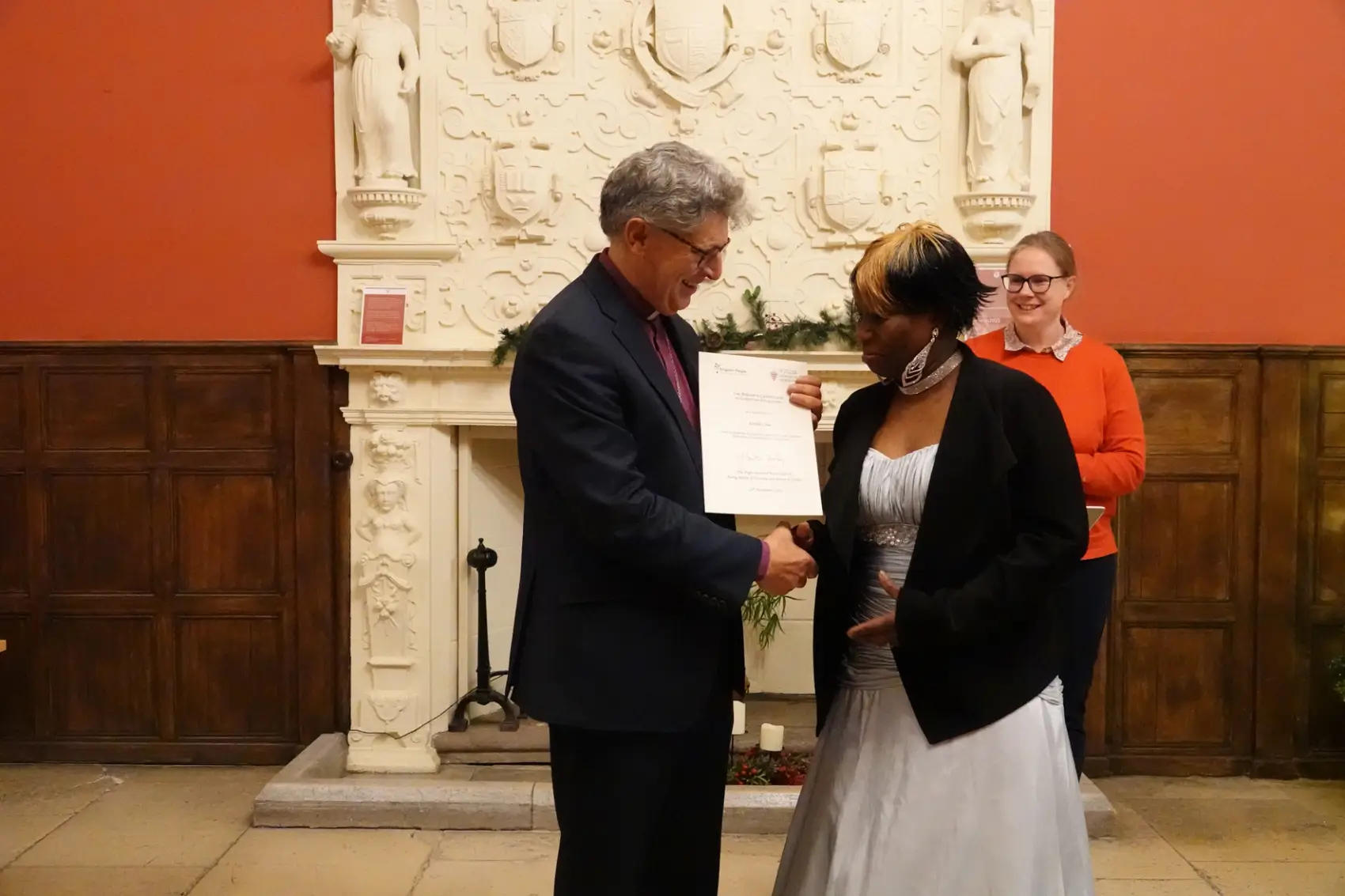 Bishop Martin handing Clotilde Lima her Bishop's certificate