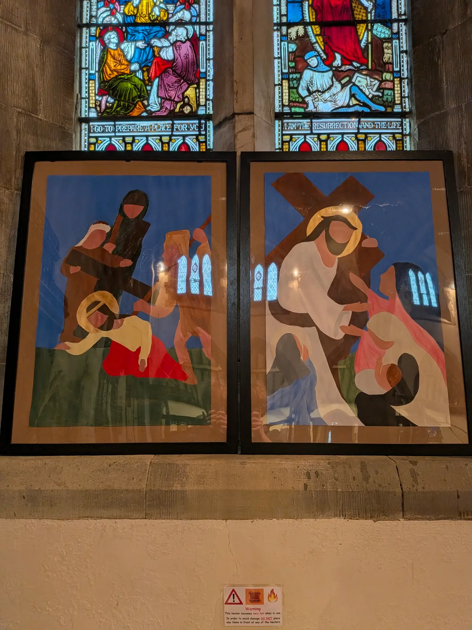 Two Stations of the Cross images in front of a window in church