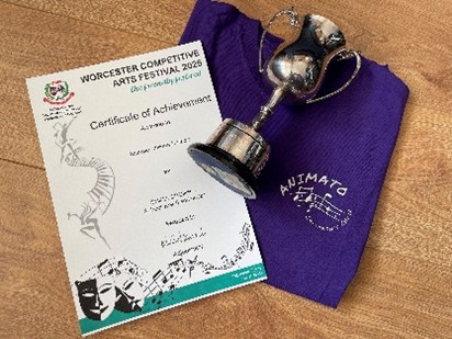 Certificate of achievement, silver cup and a folded Animato choir t-shirt