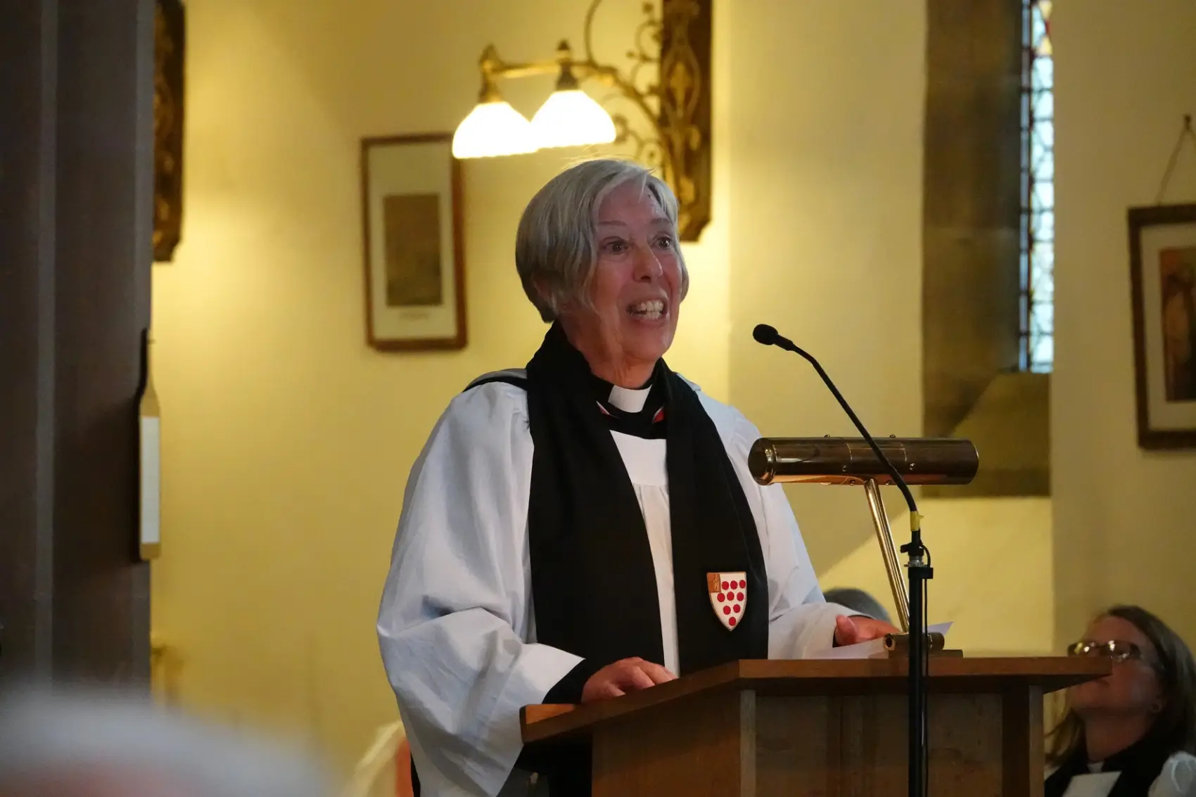 Archdeacon Nikki standing at a lecturn as she preaches