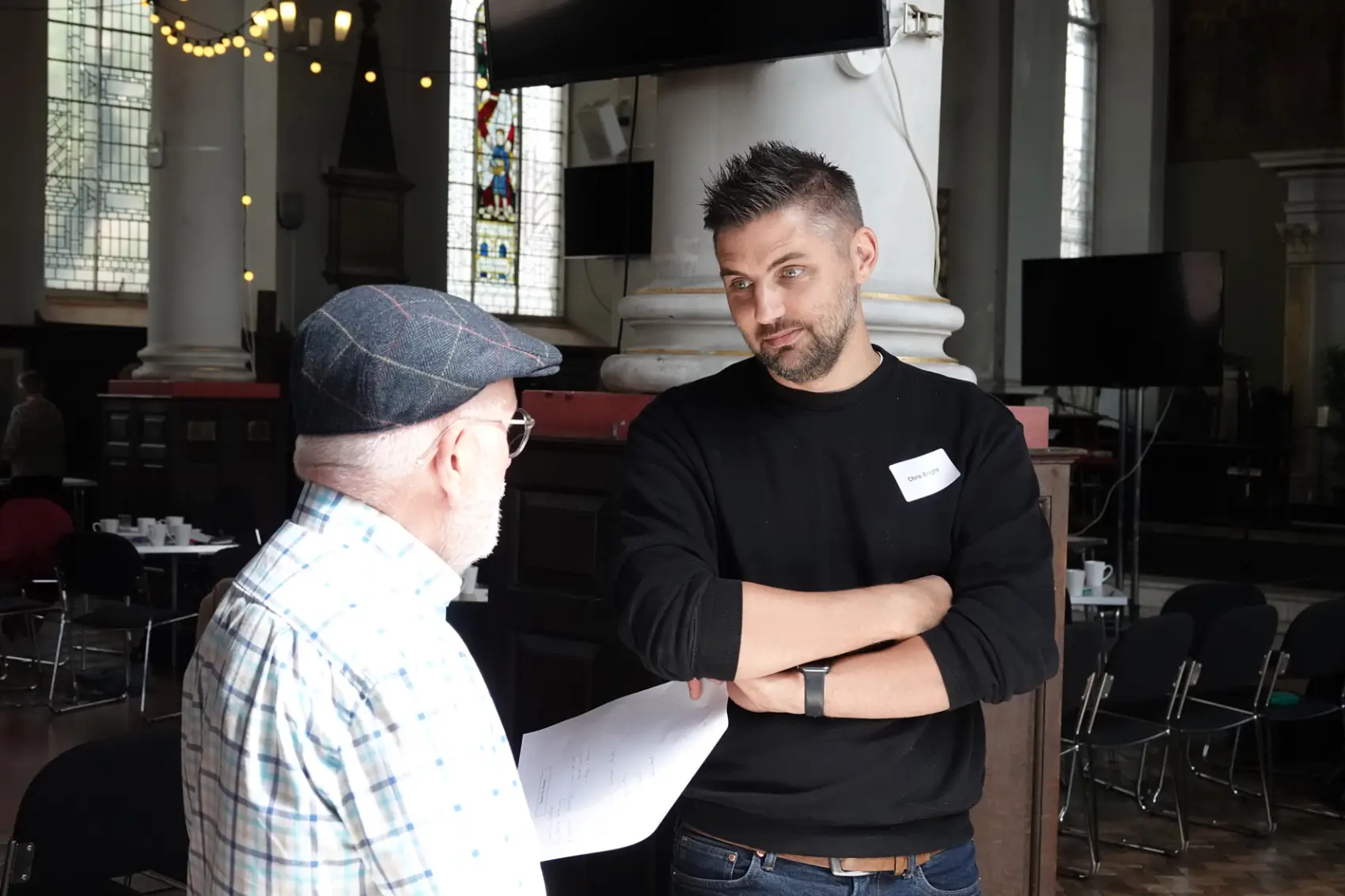 Two mission accompaniers standing in a church chatting to each other