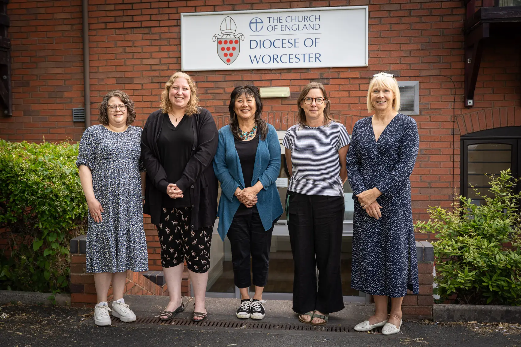 Diocesan safeguarding team standing in front of the sign for the diocesan office
