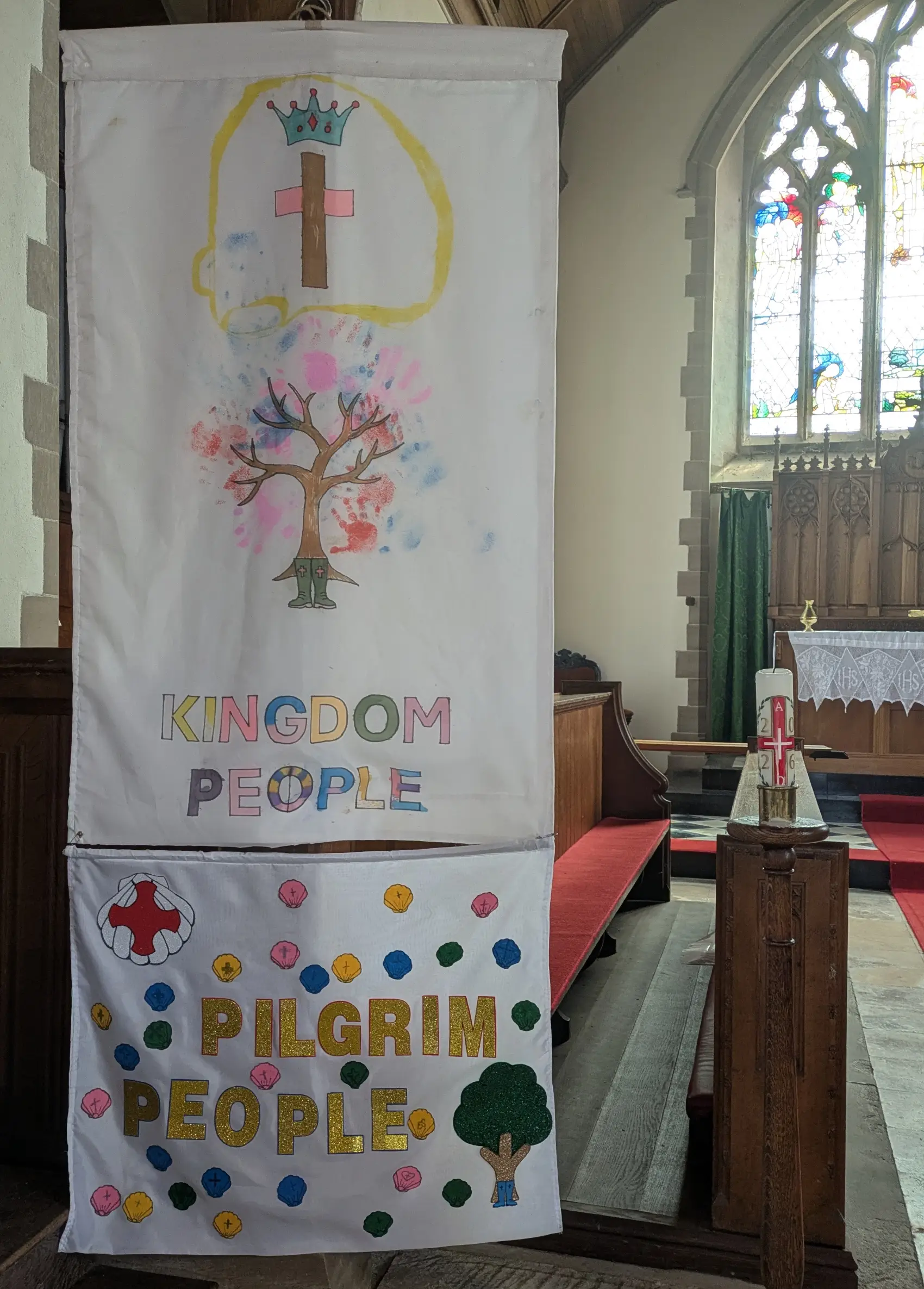 Two banners hanging in church one with Kingdom People on and the other with Pilgrim People on