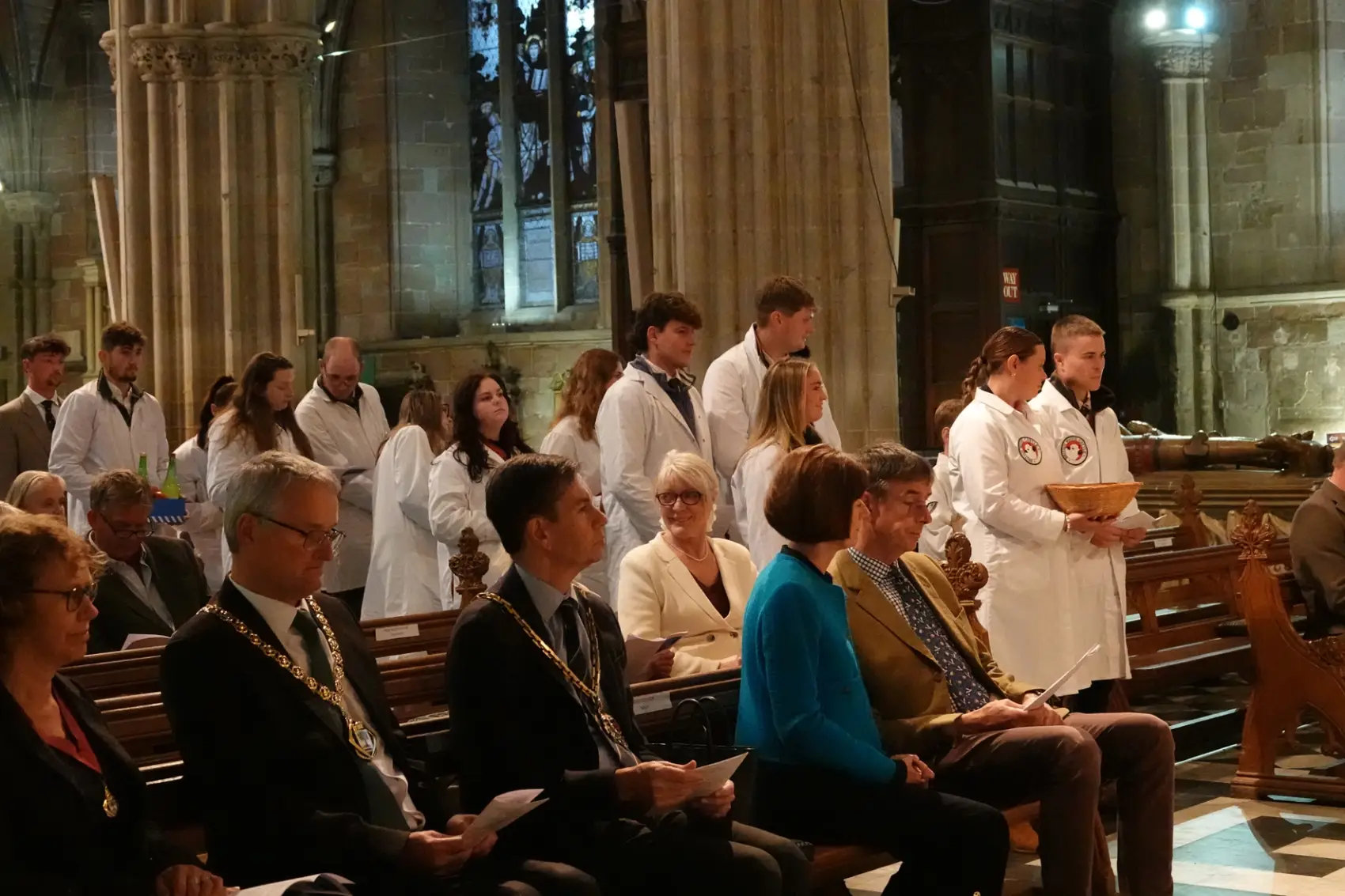 Young farmers standing in the aisle of the cathedral bringing up harvest gifts