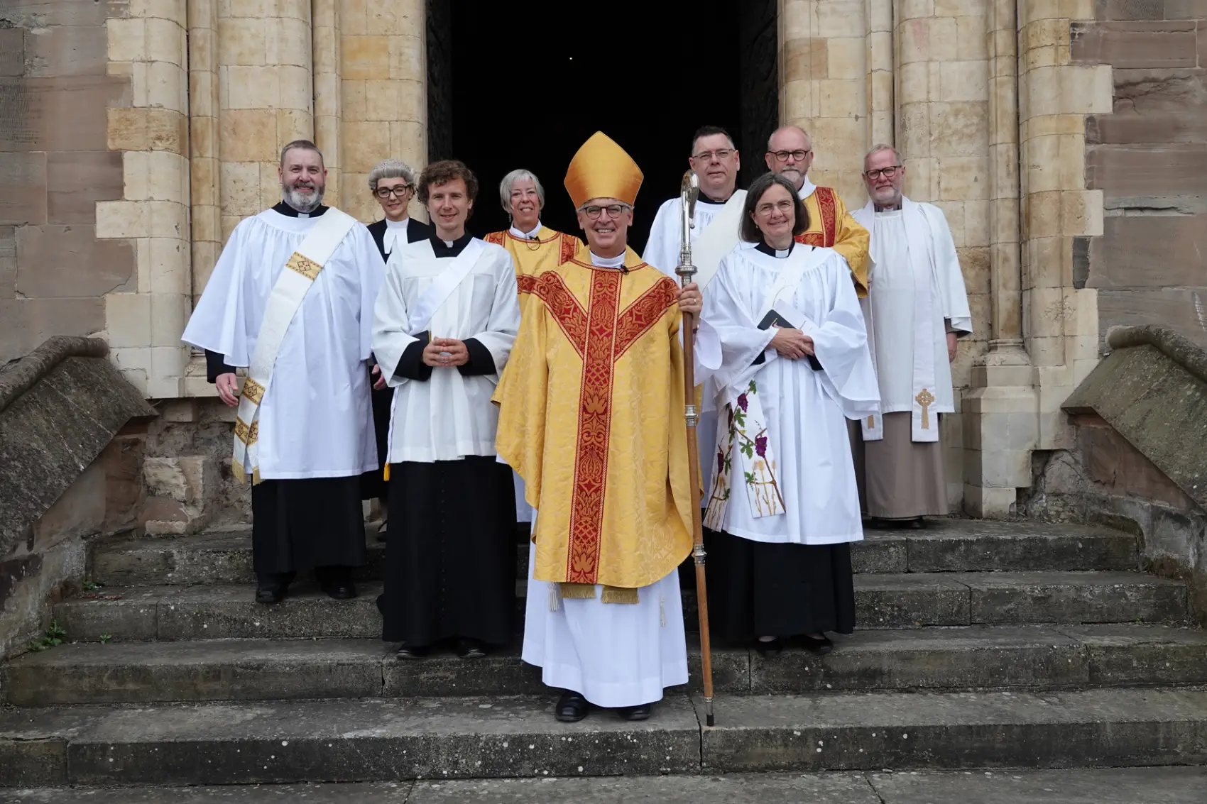 Bishop Martin standing with the deacons outside the west door of the cathedral after their ordination
