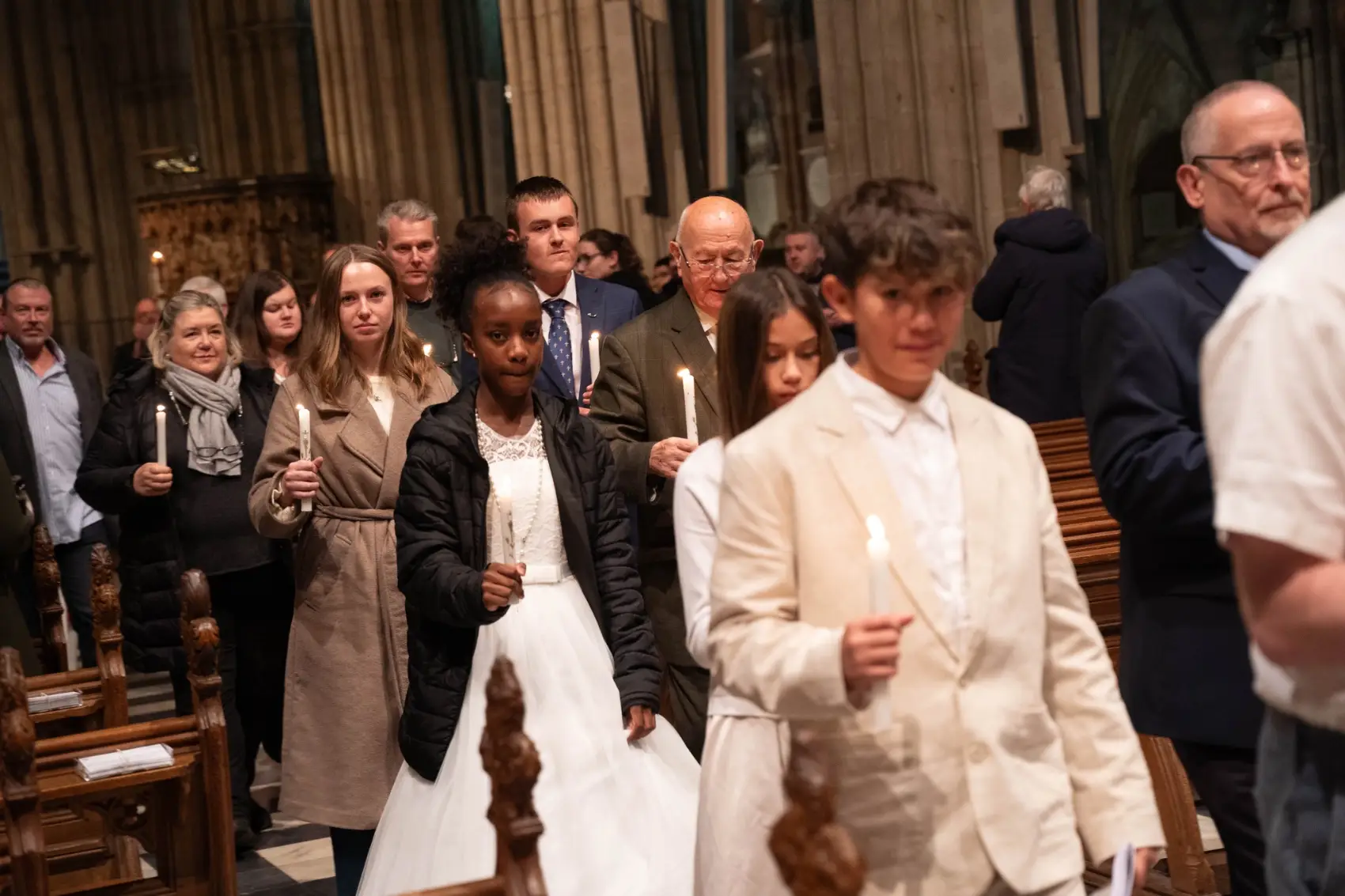 Candidates processing through to the back of the cathedral holding candles