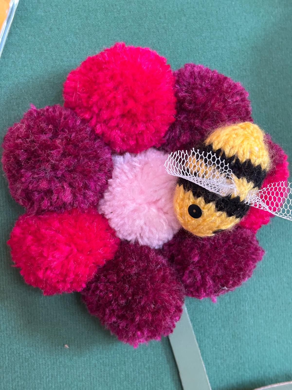 pom pom flower with a knitted bee