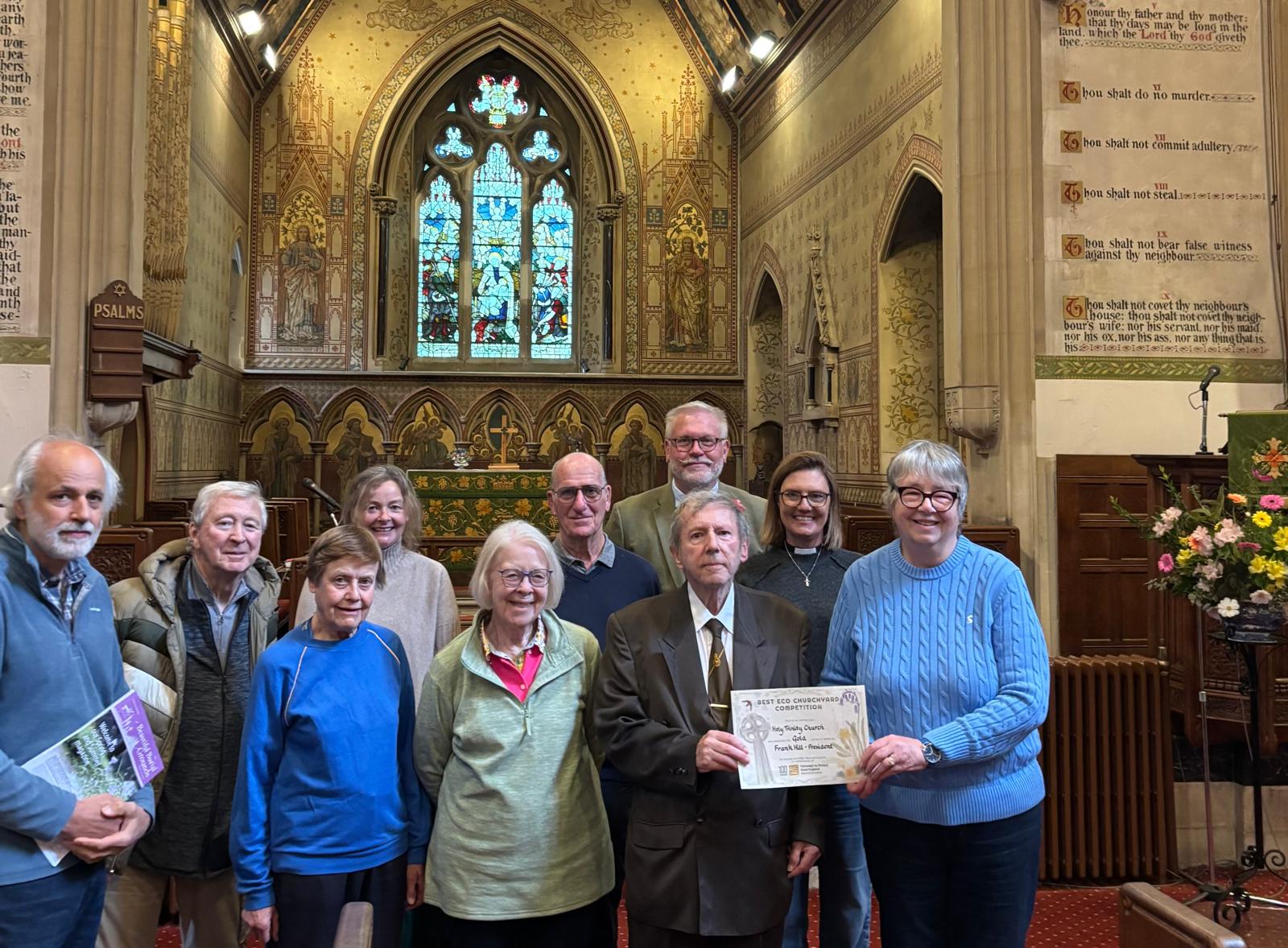 Members of Holy Trinity and St James' Church standing in the church receiving their certificate